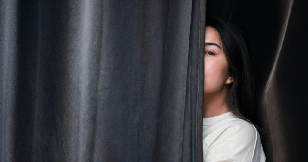 Should psychometric assessments be used for hiring? 1 Woman hiding behind curtain