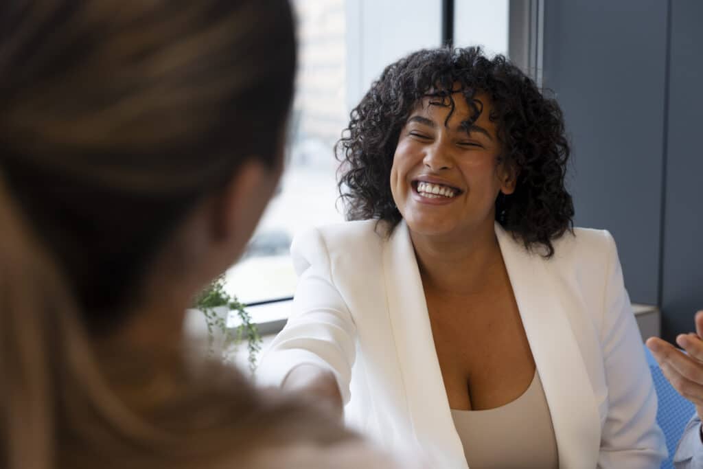 What Is a Structured Interview? Why They Work and How To Conduct One In 4 Easy Steps 2 Smiling woman in an interview