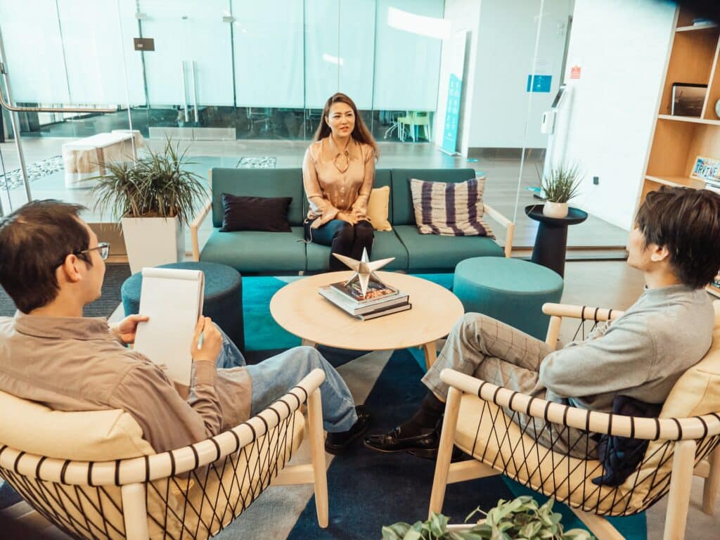 How a negative interview experience will impact your hiring process in 2023 2 Two men interviewing a lady in a relaxing interview process.