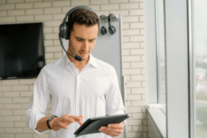 Office man wearing headphones and holding an iPad