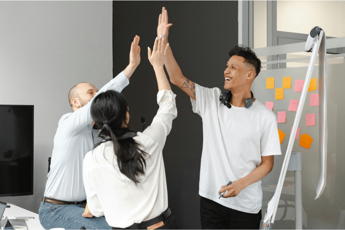 AI Recruiting 101: A Beginner’s Guide to Improving Your Hiring Process 2 Happy Coworkers in an office