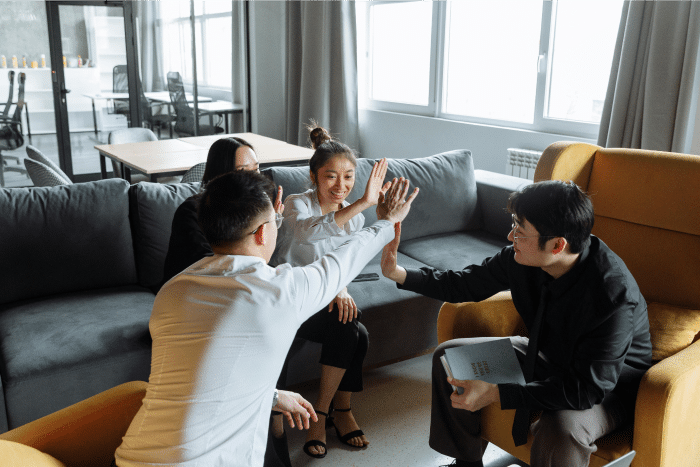 AI Recruiting 101: A Beginner’s Guide to Improving Your Hiring Process 4 Members of a Team Celebrating With a High Five