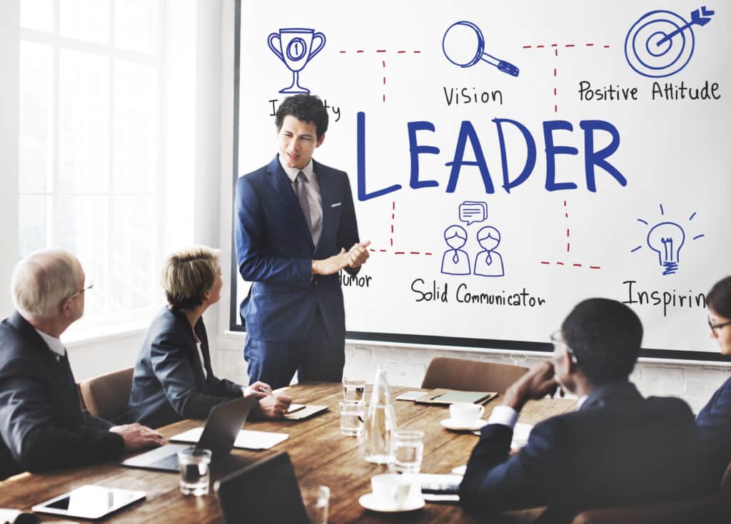 Leadership Skills Assessments: The Secret to Identifying Great Leaders 5 Photo of a man in front of a board speaking to a team